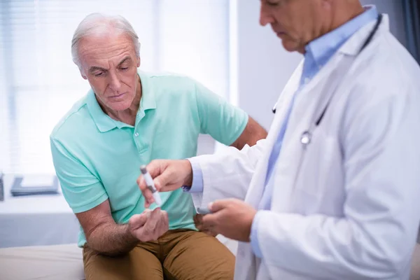 Médico examinando paciente sênior açúcar no sangue — Fotografia de Stock