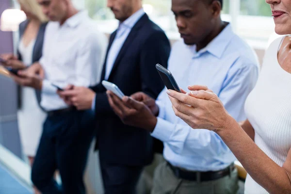 Bedrijfsleiders met behulp van digitale tablet en mobiele telefoon — Stockfoto