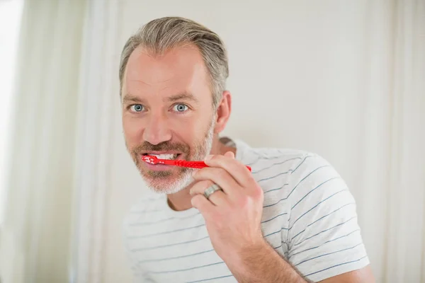 Retrato del hombre cepillándose los dientes en el baño — Foto de Stock