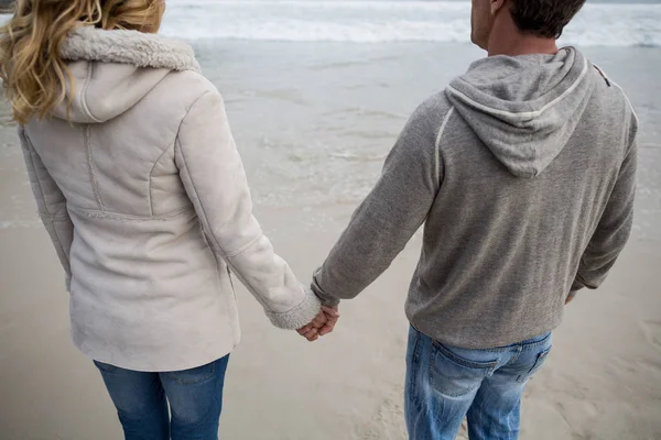 Par stående med att hålla händerna på stranden — Stockfoto