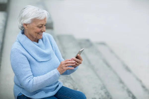 Старша жінка використовує мобільний телефон — стокове фото