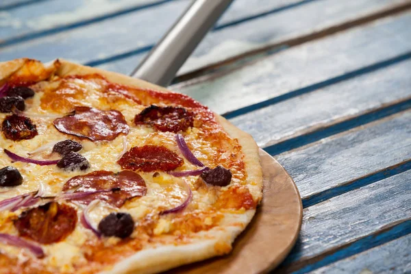 Läcker italiensk pizza serveras på pizza peel — Stockfoto
