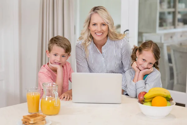 Mor och barn med laptop i köket — Stockfoto