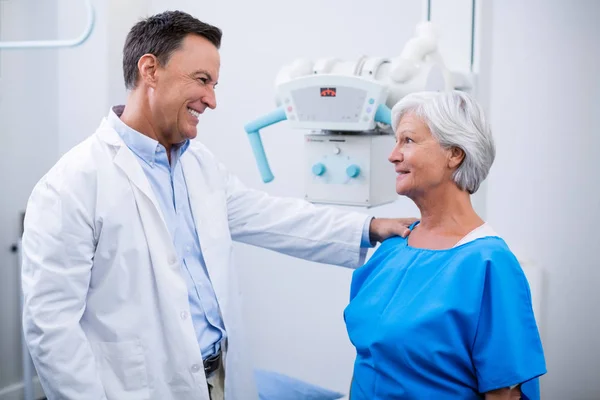 Médico interactuando con la mujer mayor durante el chequeo médico —  Fotos de Stock