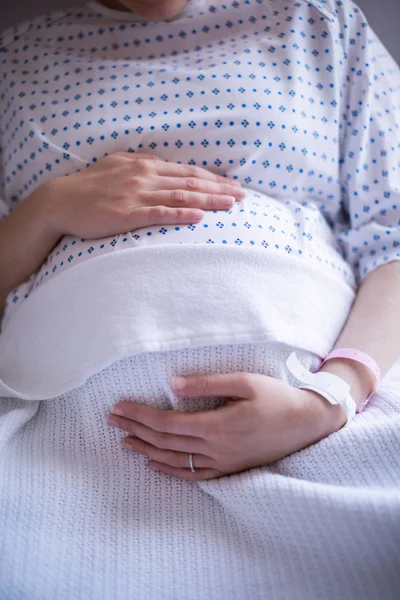 Donna incinta di mezza sezione che si rilassa sul letto d'ospedale — Foto Stock