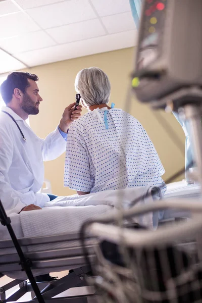 Médico examinando pacientes orelha com otoscópio — Fotografia de Stock