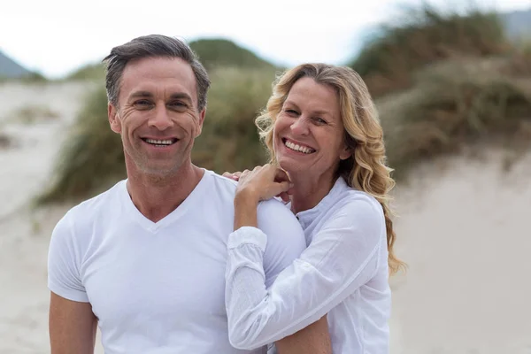 Lächelnd reifes Paar, das zusammen am Strand steht — Stockfoto