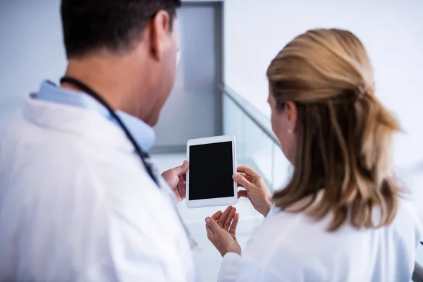 Manliga och kvinnliga läkare diskutera över digitala tablett — Stockfoto