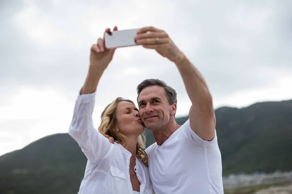 考虑使用手机拍照的成熟夫妇 — 图库照片