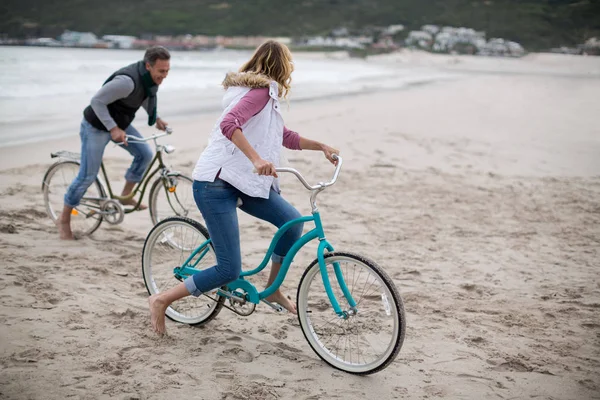 Äldre par ridning cyklar på stranden — Stockfoto