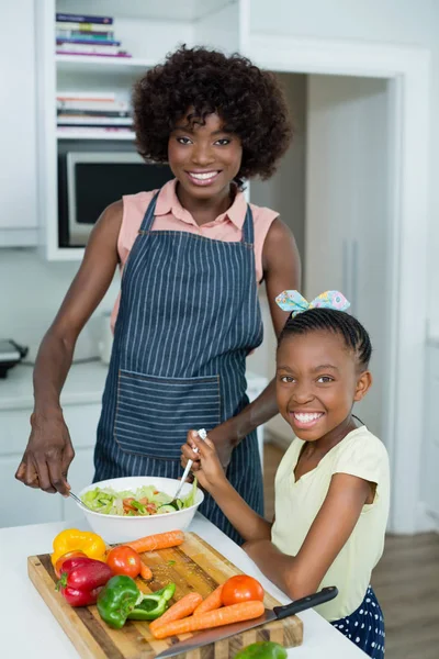 Matka a dcera připravuje salát v kuchyni doma — Stock fotografie