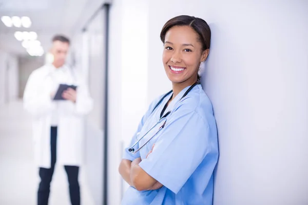 Retrato de médica de pé com os braços cruzados no corredor — Fotografia de Stock