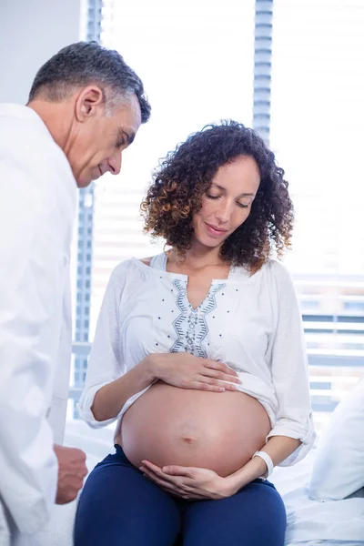 Läkare undersöka gravida kvinna i församling — Stockfoto