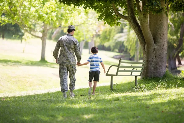 Army soldier walking with boy in park — Stock Photo, Image