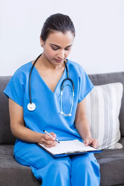 Doctora escribiendo en portapapeles — Foto de Stock