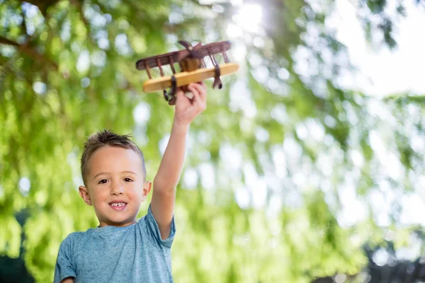 Porträtt av pojke leker med en leksak flygplanet i park — Stockfoto