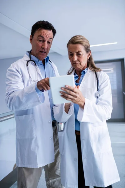 Male and female doctor discussing over digital tablet — Stock Photo, Image