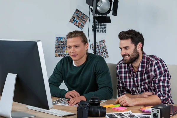 Photographers working at desk — Stock Photo, Image