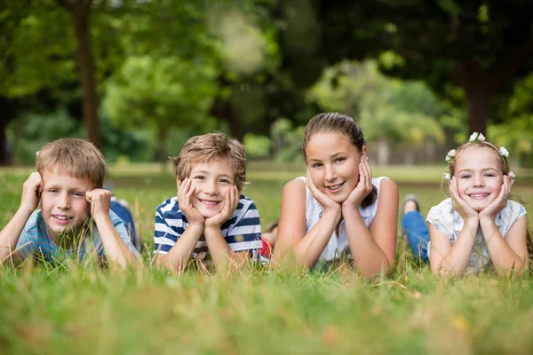 Szczęśliwe dzieci leżąc na trawie — Zdjęcie stockowe
