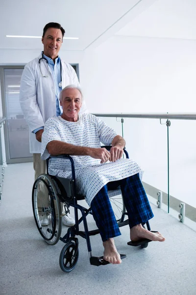 Porträt eines lächelnden Arztes mit einem älteren Patienten im Rollstuhl — Stockfoto