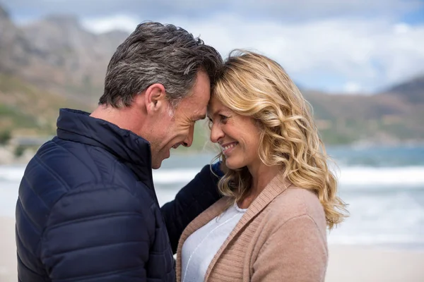 Ouder paar staande aangezicht tot aangezicht op het strand — Stockfoto