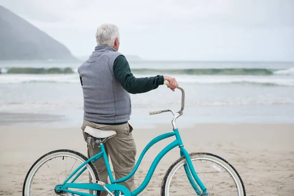 Senior férfi kerékpár a parton állva — Stock Fotó