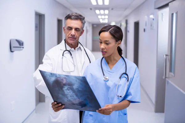 Doctors examining x-ray in corridor — Stock Photo, Image