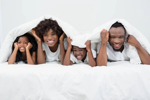 Портрет батьків і дітей, що лежать на ліжку — стокове фото