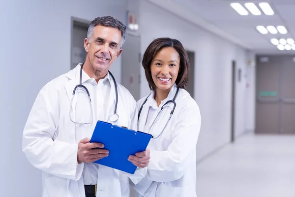 Портрет улыбающихся врачей, стоящих в коридоре — стоковое фото
