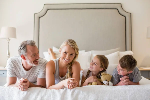 Föräldrar med sina barn liggande på sängen i sovrummet — Stockfoto