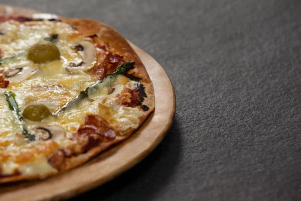 Deliciosa pizza italiana servida sobre tabla de madera — Foto de Stock