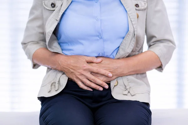 Mid section of female patient suffering from stomach ache — Stock Photo, Image