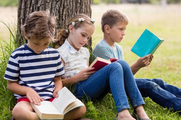 Kids reading books in park — Stock Photo, Image