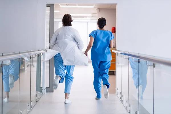 Enfermeira e médico correndo no corredor hospitalar — Fotografia de Stock