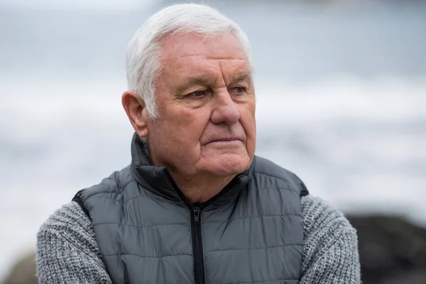 Homme âgé réfléchi debout près de la plage — Photo