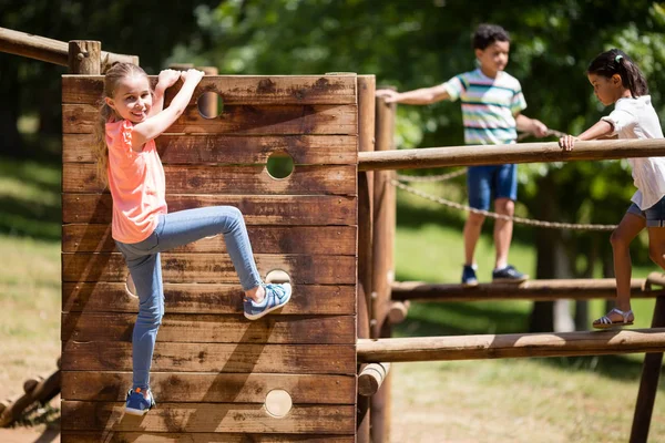 Barn som leker på en lekplats rida i park — Stockfoto