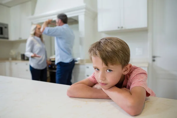 Сумний хлопчик слухає батьків, сперечаючись — стокове фото
