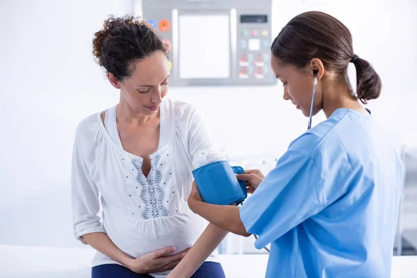 Médico de control de la presión arterial de la mujer embarazada — Foto de Stock