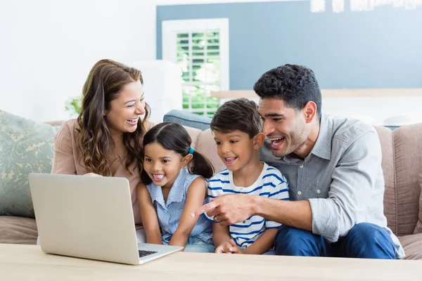 Rodiče a děti používat přenosný počítač v obývacím pokoji — Stock fotografie