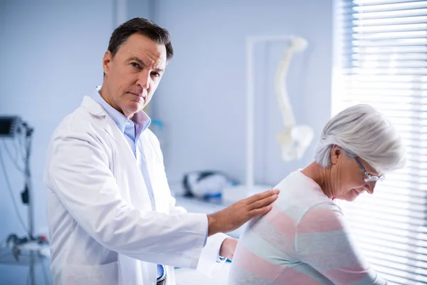 Retrato del fisioterapeuta dando masaje de espalda al paciente mayor — Foto de Stock