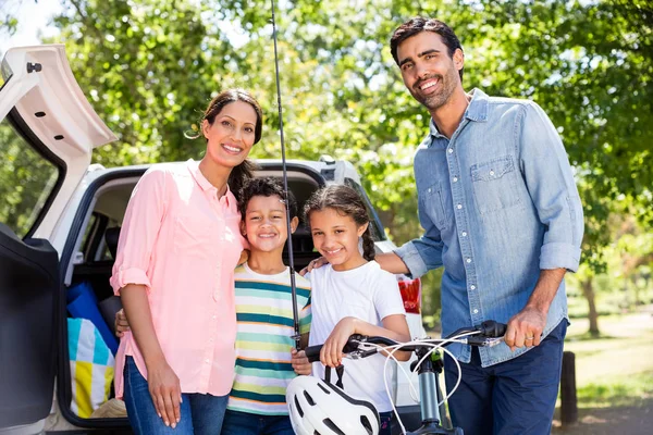 Счастливая семья на пикнике, стоящая рядом с машиной — стоковое фото