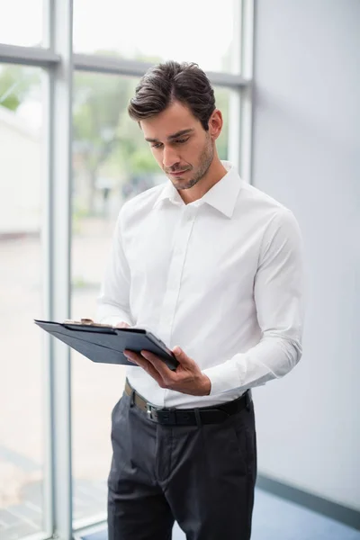 Businessman looking at clipboard — Stock Photo, Image
