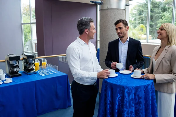 Dirigeants d'entreprise interagissant les uns avec les autres tout en prenant un café — Photo