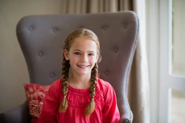 Porträt eines lächelnden süßen Mädchens auf Stuhl sitzend — Stockfoto