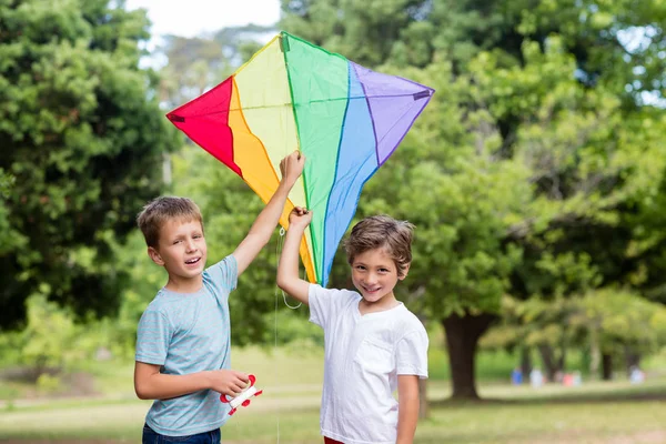 Två pojkar håller en kite i park — Stockfoto