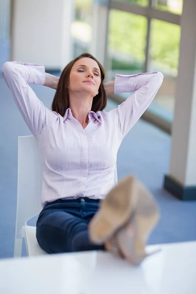 Geschäftsfrau entspannt sich am Schreibtisch — Stockfoto