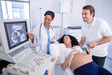 Doctor doing ultrasound scan for pregnant woman clipart