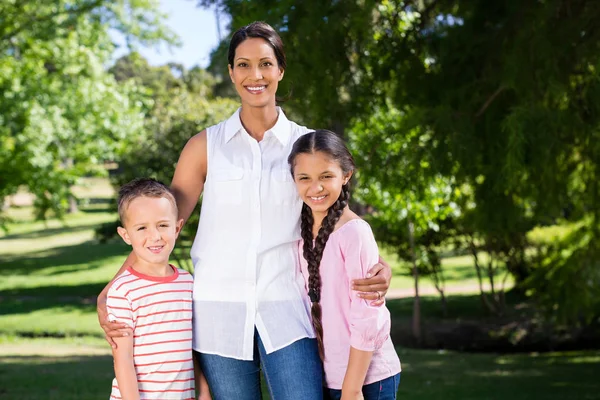 Ritratto di madre in piedi con i suoi figli nel parco — Foto Stock