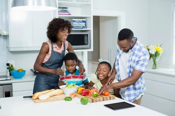 Ebeveynler ve çocuklar mutfakta salata hazırlık — Stok fotoğraf