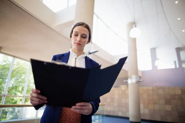 Mujer de negocios mirando portapapeles — Foto de Stock